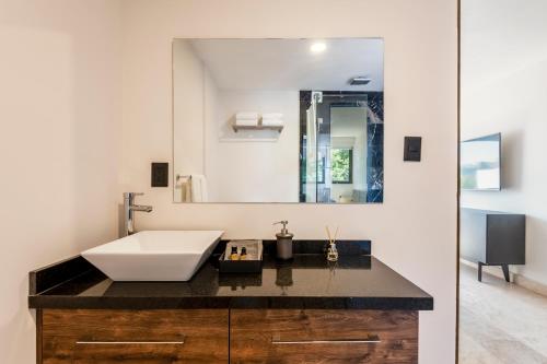 a bathroom with a sink and a large mirror at The Corner Condesa in Mexico City