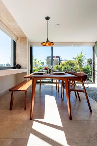a dining room with a wooden table and a large window at The Corner Condesa in Mexico City