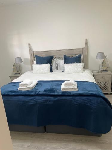 - un lit bleu avec 2 serviettes dans l'établissement Marielitsa Inn, à Germiston