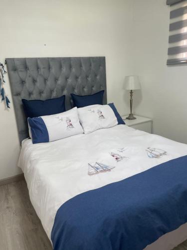 a large bed with blue and white sheets and pillows at Marielitsa Inn in Germiston