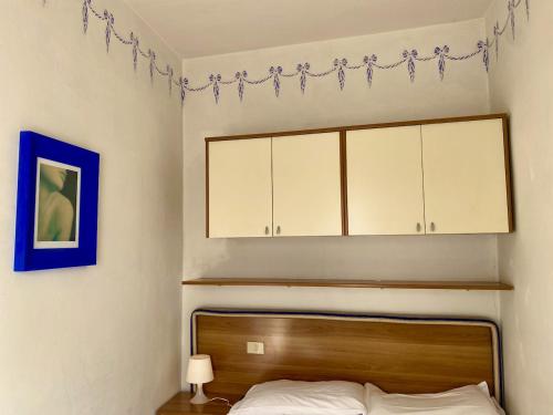 a bedroom with a bed with a wooden headboard and cabinets at Appartamento in centro：Montecatini Terme in Montecatini Terme