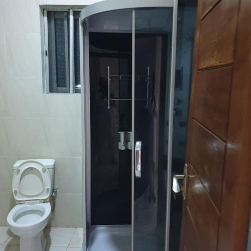 a bathroom with a toilet and a glass shower stall at ORCHID House Stylish 3BDR Terrace Duplex Free WiFi DSTV in Lekki