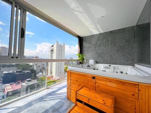 a bathroom with a tub and a large window at Haven A Design Hotel in Medellín
