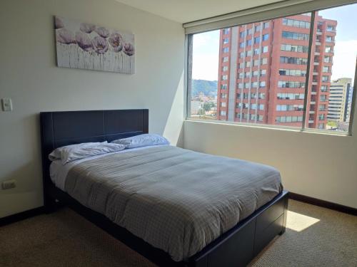 1 dormitorio con cama y ventana grande en Confort suite whit view, en Quito