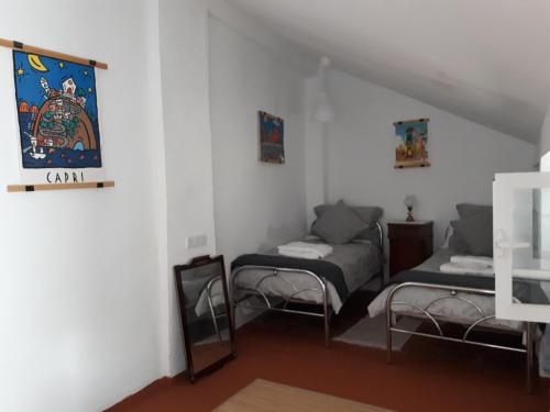 ein Wohnzimmer mit 2 Betten und einem Spiegel in der Unterkunft The Jasmine House in Olvera