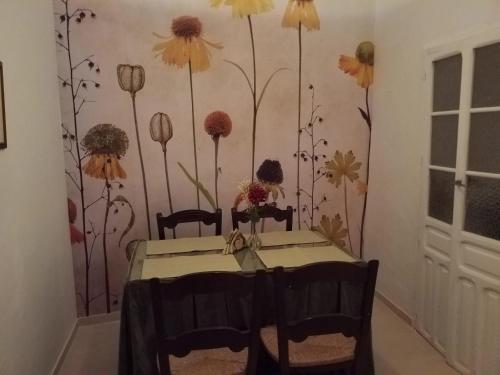 a dining room with a table and flowers on the wall at The Jasmine House in Olvera