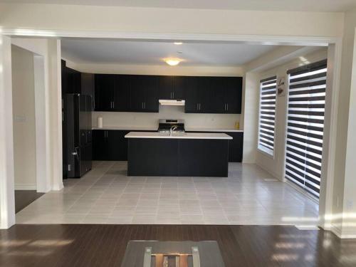 a kitchen with black cabinets and a kitchen island at 537 Veterans Dr Brampton ON L7A 5A6 in Brampton