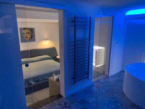 Cette chambre bleue comprend un lit et un miroir. dans l'établissement SUITE Nobile, à Catane