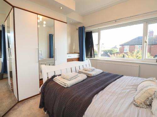 a bedroom with a bed with a large window at Haven in Lytham St Annes
