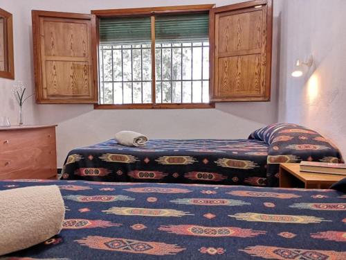 1 dormitorio con 2 camas y ventana en Casa Rural La Colina, en Calasparra