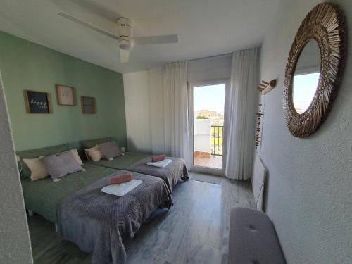 a bedroom with two beds and a mirror and a window at Casa Alegria - Laguna Beach in Torrox Costa