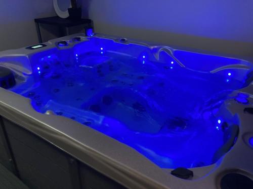 a blue tub in a bathroom with a blue light at Aparthotel Des 2 Caps in Ambleteuse