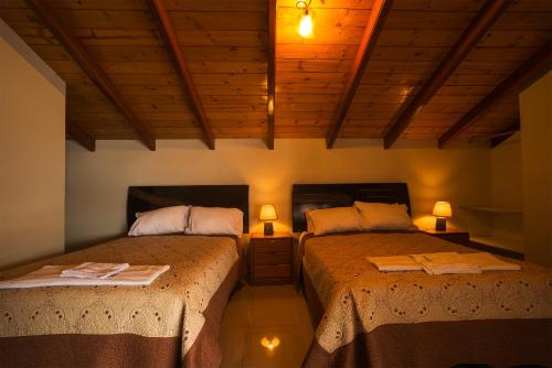 2 camas en una habitación con 2 lámparas en las mesas en Hostal Catequil en Cajamarca