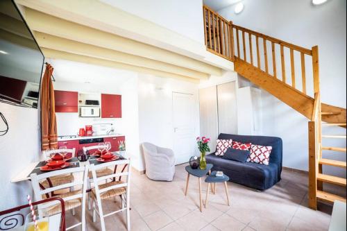 a living room with a blue couch and a kitchen at JASSE CAMARGUAISE 535 - PISCINE CLIM PARKING FAMILLE - TOP PROS SERVICESConciergerie in Gallargues-Le-Montueux