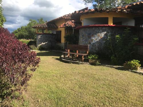 a bench in the yard of a house at Hotel del Campo in Quimbaya