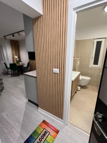 a bathroom with a wooden door with a tub and a sink at Oxana Apartments - 3 camere - Timisoara in Timişoara