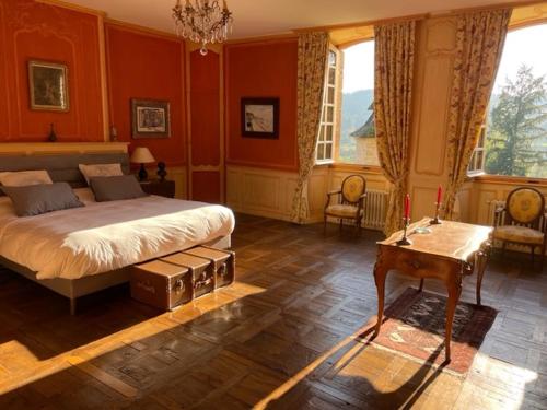 a bedroom with red walls and a bed and a table at Castle in the beautiful French countryside with all modern comfort in Terrou
