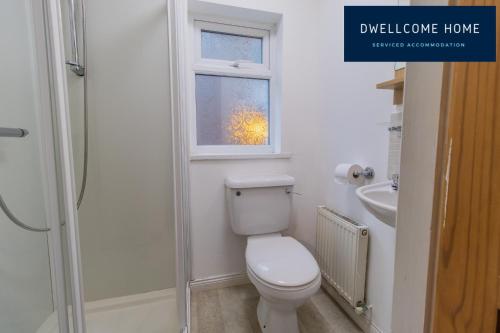 a bathroom with a toilet and a window at Dwellcome Home Ltd Spacious 8 Ensuite Bedroom Townhouse - see our site for assurance in South Shields