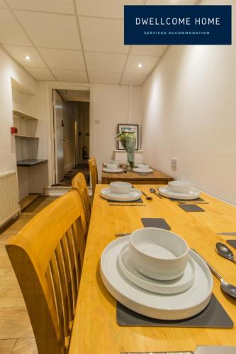 a conference room with a long table with plates on it at Entire 8 Ensuite Bedroom Coastal Holiday Home Townhouse, Free Parking, Fully Equipped Kitchen, Dining Room & Lounge, Perfect for Family Gatherings, Long Term Contractor, Relocation, etc Stays, 20 mins to Sunderland & Newcastle, See our Site for Assurance in South Shields