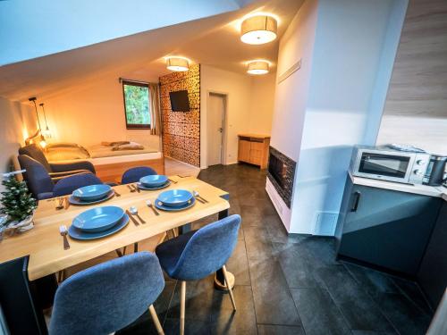 - un salon avec une table en bois et des chaises bleues dans l'établissement Apartmanovy Dom Vila Vista, à Demänovská Dolina