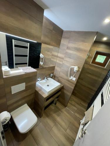 a bathroom with a white toilet and a sink at Apartmanovy Dom Vila Vista in Belá