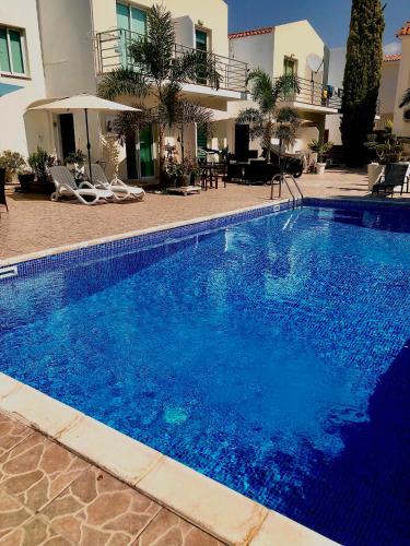 a large blue swimming pool in front of a building at Estia Luxury Maisonette in Paphos