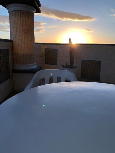 a table and chairs on a balcony with the sunset at Maicao Internacional in Maicao