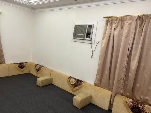 ein Wohnzimmer mit einem Sofa und einem Fenster in der Unterkunft هدى الحجاز للشقق المفروشة in Mekka