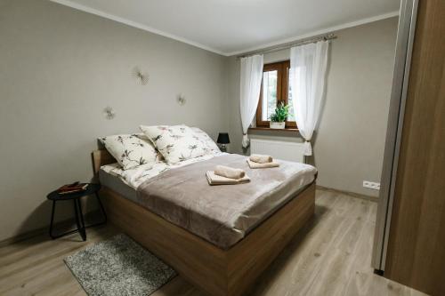 a bedroom with a bed with two towels on it at Apartament KARO 1 Karkonosze in Jelenia Góra