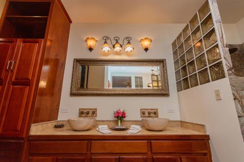 Baño con 2 lavabos y espejo en Captain Morgan's Retreat, en San Pedro