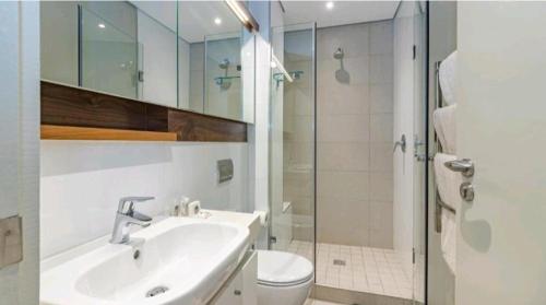 a bathroom with a sink and a toilet and a shower at Zimbali Suite 217 in Ballito