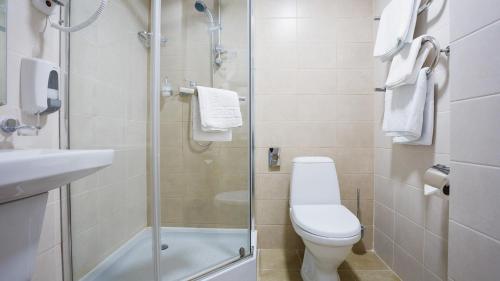 a bathroom with a toilet and a glass shower at Park Hotel in Tiraspol