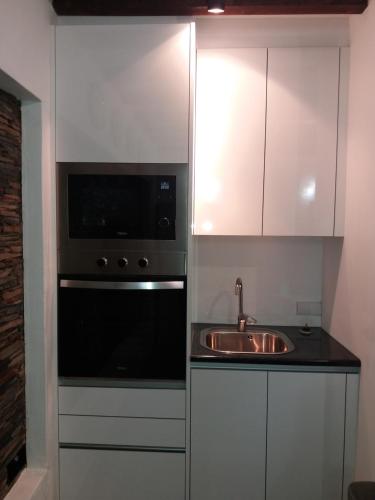 a kitchen with a sink and a microwave at Casa da Muralha Suíte in Monsaraz