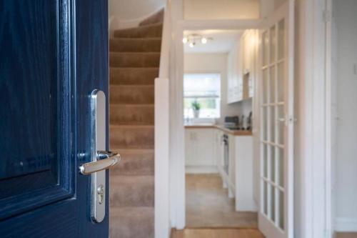 a blue door leading into a kitchen with a staircase at 3 Bed House/Garden/Wi-Fi/Parking/Central Location in Stoughton