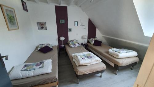 um quarto com três camas num quarto em Grand gîte Touraine 300m2 em La Membrolle-sur-Choisille