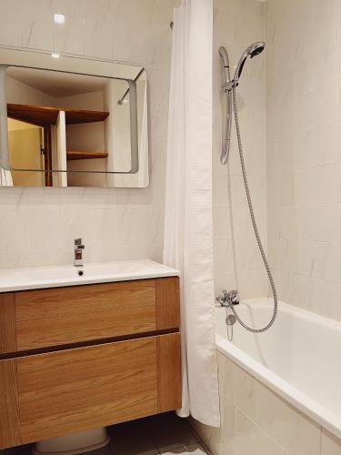 y baño con lavabo y ducha con espejo. en Appartement La Tania, en Courchevel