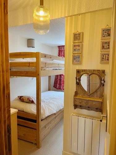 a bedroom with two bunk beds and a mirror at Appartement La Tania in Courchevel
