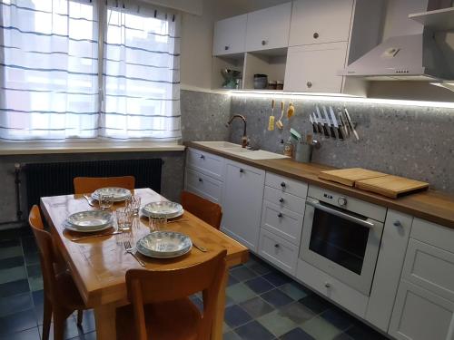 une cuisine avec une table avec des assiettes et des verres dessus dans l'établissement Rétro Malo, à Dunkerque