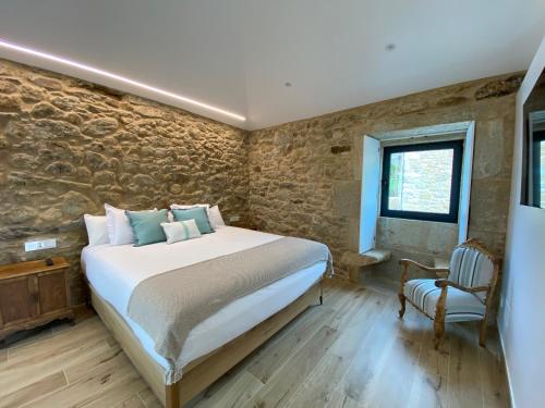 sypialnia z dużym łóżkiem i krzesłem w obiekcie Morada Atlántica w mieście A Coruña