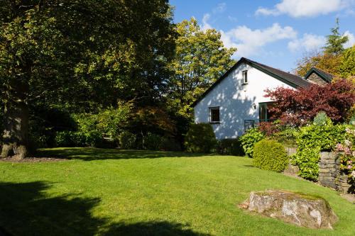 a white house with a yard with green grass at Merewood Lodge in Ambleside