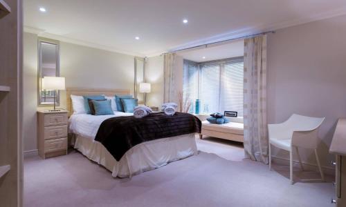 a bedroom with a bed and a desk and a window at Merewood Lodge in Ambleside