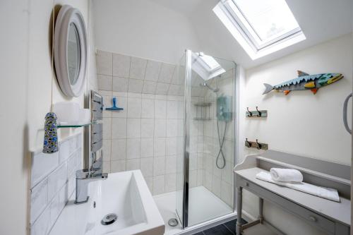 een badkamer met een douche en een wastafel bij Lifeboat Cottage by Big Skies Cottages in Brancaster