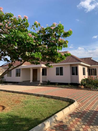 a house with a red roof and a brick driveway at Dodoma, Tukae Inn in Dodoma