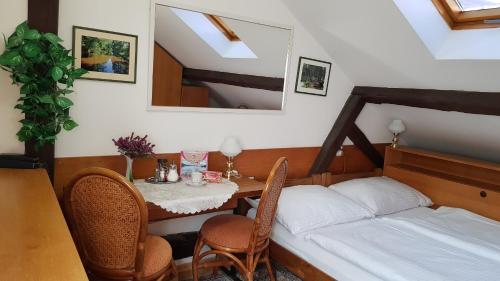 a small room with a table and a bed at Modrá růže Třeboň in Třeboň