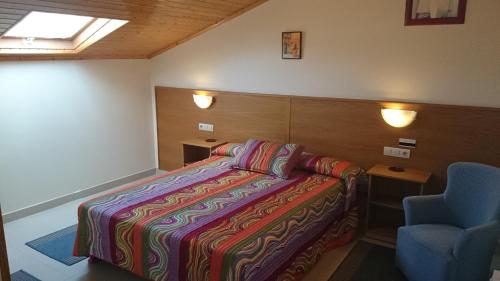 バルドビーニョにあるHotel Valdoviñoのベッドルーム1室(ベッド1台、青い椅子付)