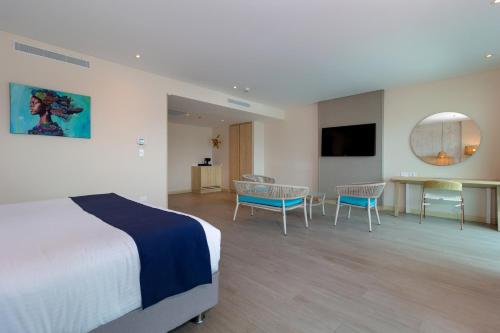 a hotel room with a bed and a table and chairs at Aquamare Hotel in San Andrés