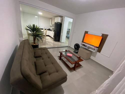 a living room with a couch and a television at Casa em Itajaí Balneário Camboriú e Parque Beto Carrero in Itajaí