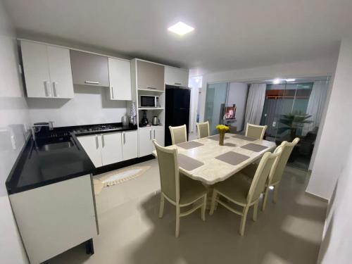 a kitchen and dining room with a table and chairs at Casa em Itajaí Balneário Camboriú e Parque Beto Carrero in Itajaí