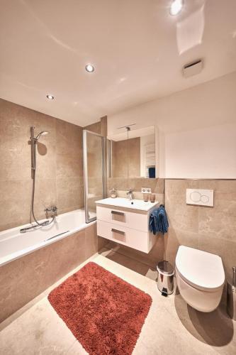 a bathroom with a toilet and a sink and a tub at Haus Josef-Herold-Straße 17a in Kitzbühel