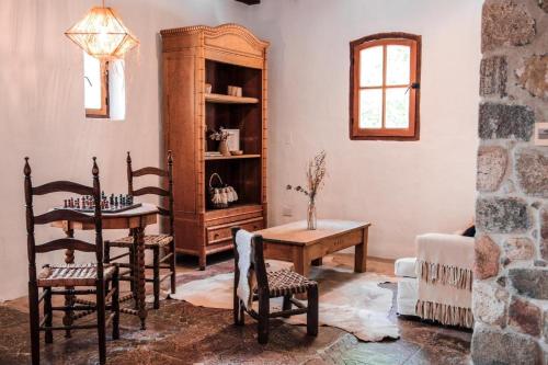 a living room with a table and chairs and a cabinet at Castillo de Piedra Tafi del Valle in Tafí del Valle